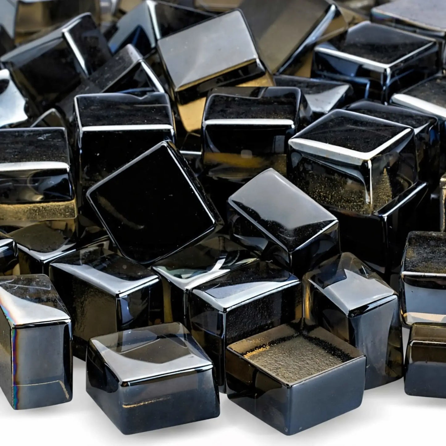 Detailed close-up of bronze tempered fire glass cubes in the Luster 2.0 finish, showing their smooth edges and reflective, smoky amber tones. The polished surfaces catch the light, emphasizing the depth and warmth these cubes bring to modern fire features.