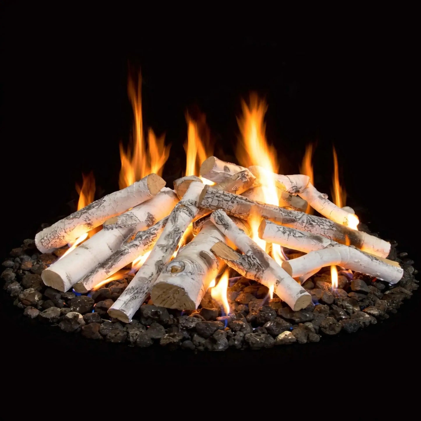HPC Fire Hearth Products Controls Aspen Birch gas fire pit logs shown in a lifestyle setting with active flames, arranged over dark fire glass media. The realistic birch-style logs glow with warm orange flames against a black background, showcasing how these ceramic logs enhance the visual appeal of a gas fire pit with a natural wood-burning look and modern fire feature design.