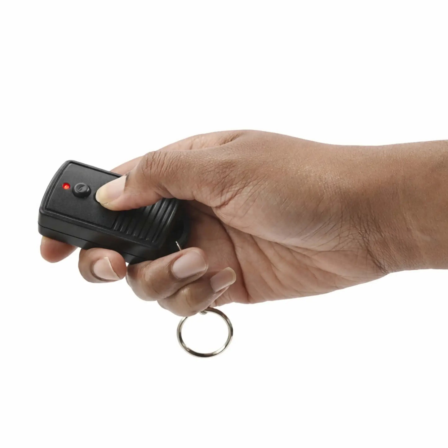 Lifestyle image showing a person holding a black handheld on/off remote control with a keyring attachment, actively pressing one of the buttons. The remote features a red LED indicator light and textured grip, demonstrating ease of use and portability for controlling a fire pit or fireplace system.