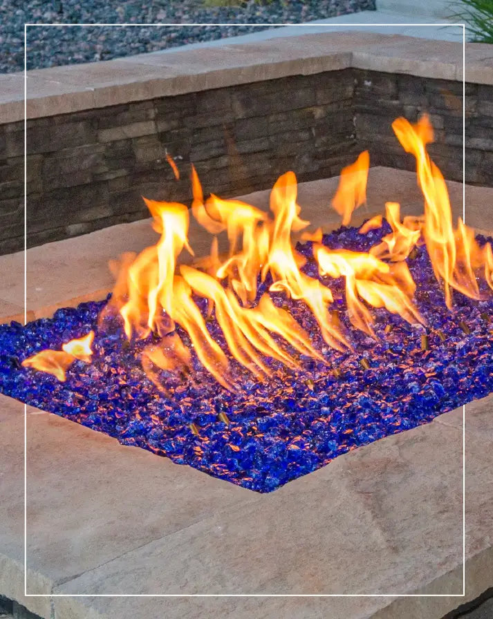 Vibrant blue fire glass with dancing flames in a modern outdoor fire pit, enhancing ambiance and style for backyard spaces.