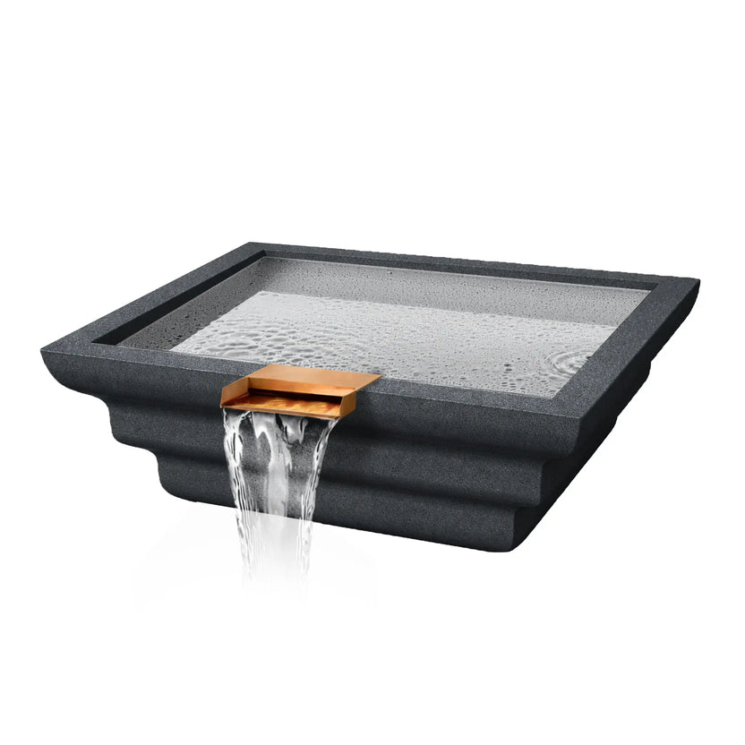 Angled product view of the Flame Havens Serenity Series ripple square rounded water bowl in a dark graphite finish. The modern square basin features layered ripple-style exterior contours and a copper scupper spillway that pours a smooth sheet of water over the front edge. The basin surface shows gentle water movement, highlighting the architectural pool water feature designed for luxury outdoor pools and landscapes.