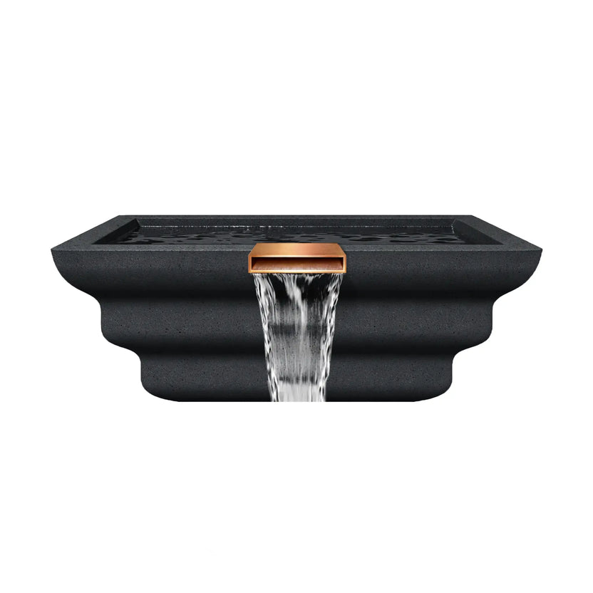 Front elevation view of the graphite Serenity Series square ripple water bowl with a centered copper spillway. Water flows evenly from the rectangular scupper, forming a smooth waterfall stream cascading downward. The textured graphite finish and stacked ripple profile give the bowl a sculpted architectural appearance ideal for modern poolside water features.