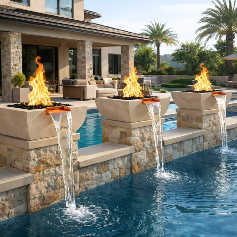Luxury backyard pool installation featuring three white Serenity Series fire and water bowls mounted along a raised stone pool wall. Each bowl burns a tall flame above black fire media while copper spillways send smooth waterfall streams into the blue swimming pool below, creating an elegant resort-style outdoor atmosphere.