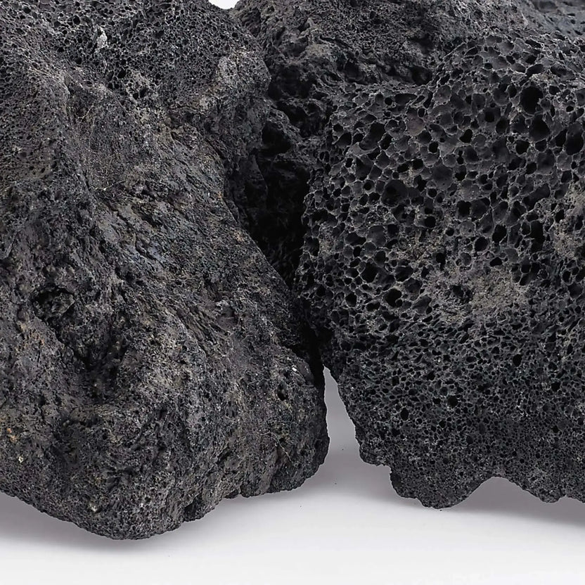 Close-up view of extra extra large lava rock revealing dense volcanic vesicles, rough texture, and natural dark gray coloration with subtle mineral variations.
