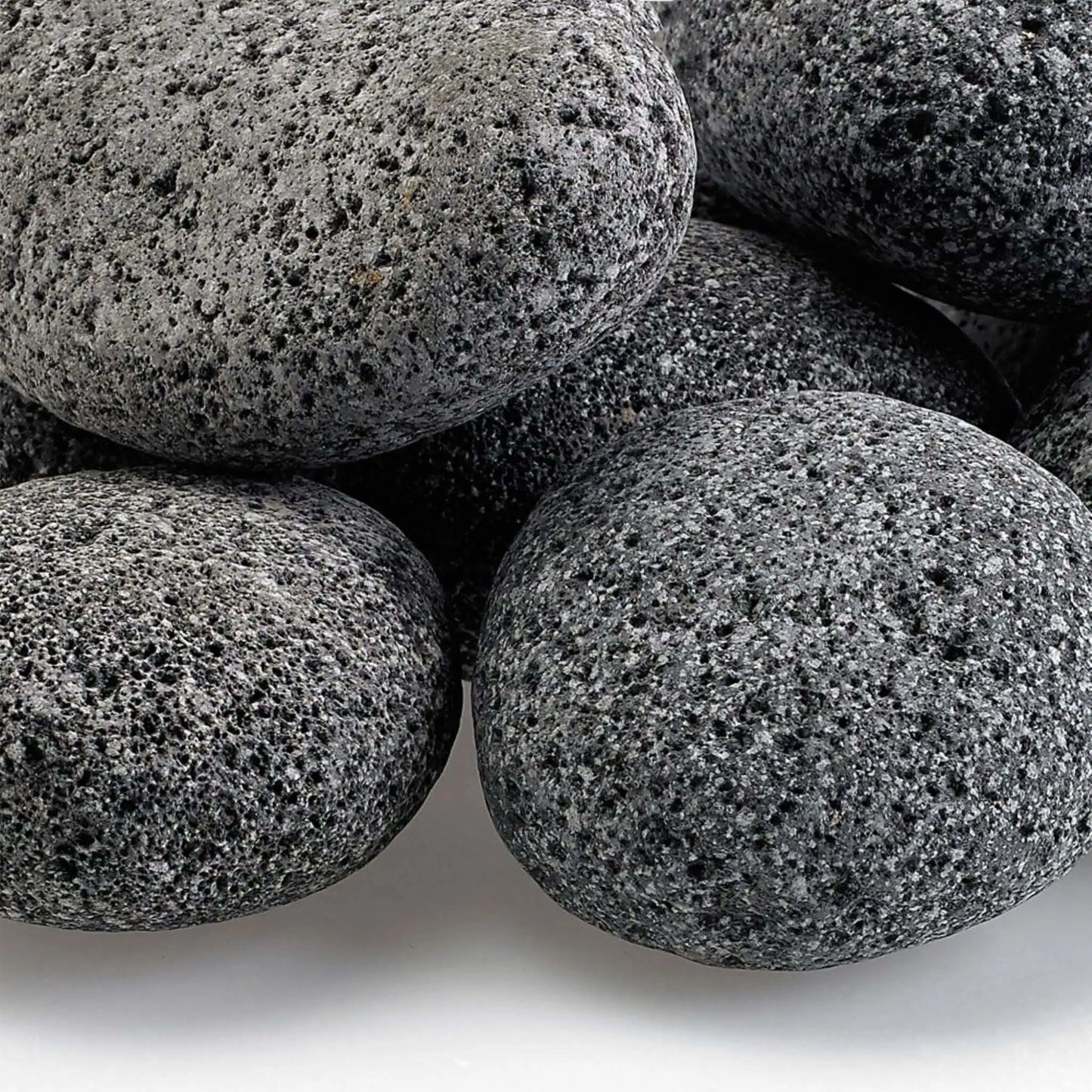Close-up view of Large gray lava stones highlighting their rough, pitted volcanic surface, natural speckling, and uneven texture that enhances flame dispersion in fire pit burners.