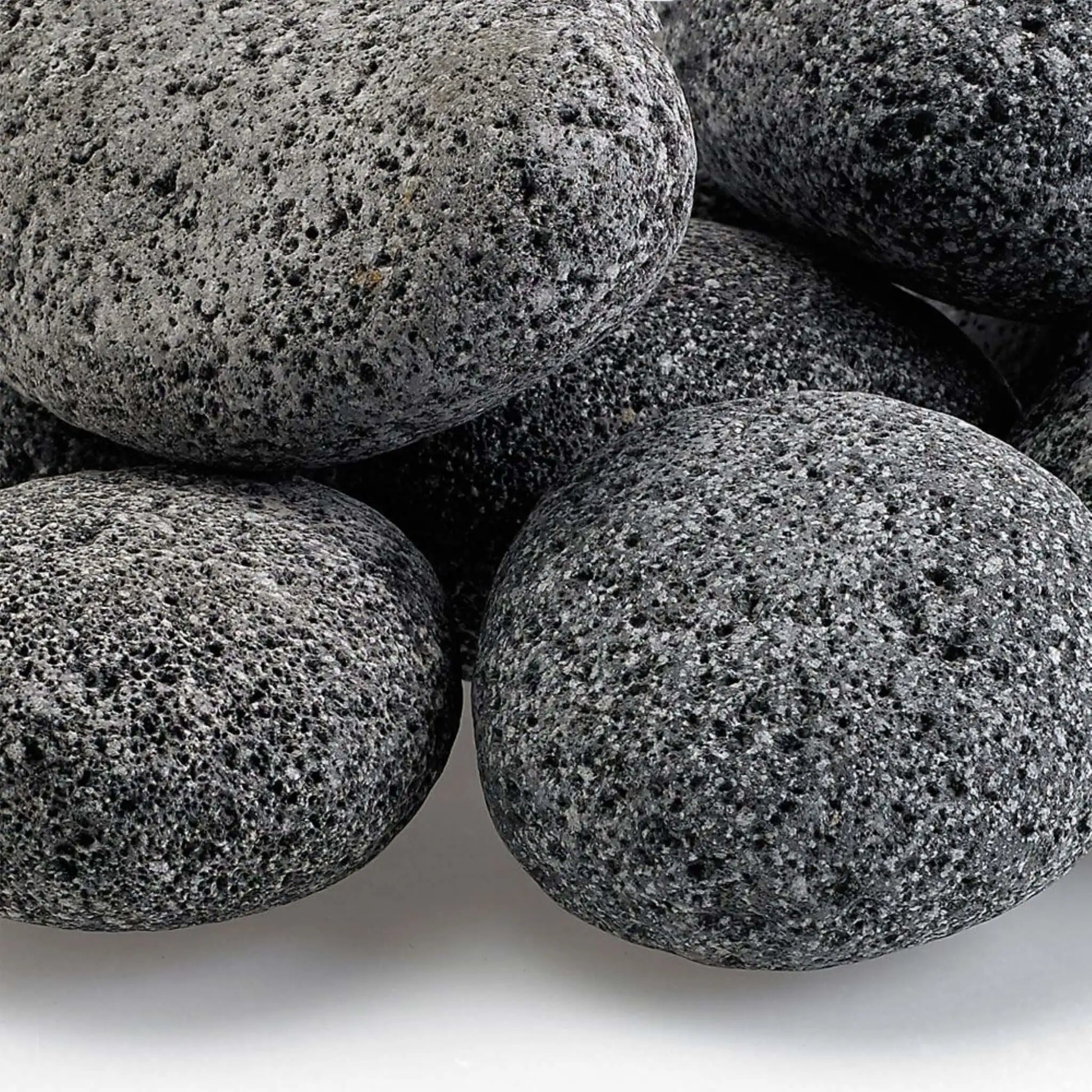 Close-up view of Large gray lava stones highlighting their rough, pitted volcanic surface, natural speckling, and uneven texture that enhances flame dispersion in fire pit burners.