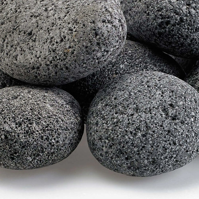 Close-up view of Large gray lava stones highlighting their rough, pitted volcanic surface, natural speckling, and uneven texture that enhances flame dispersion in fire pit burners.