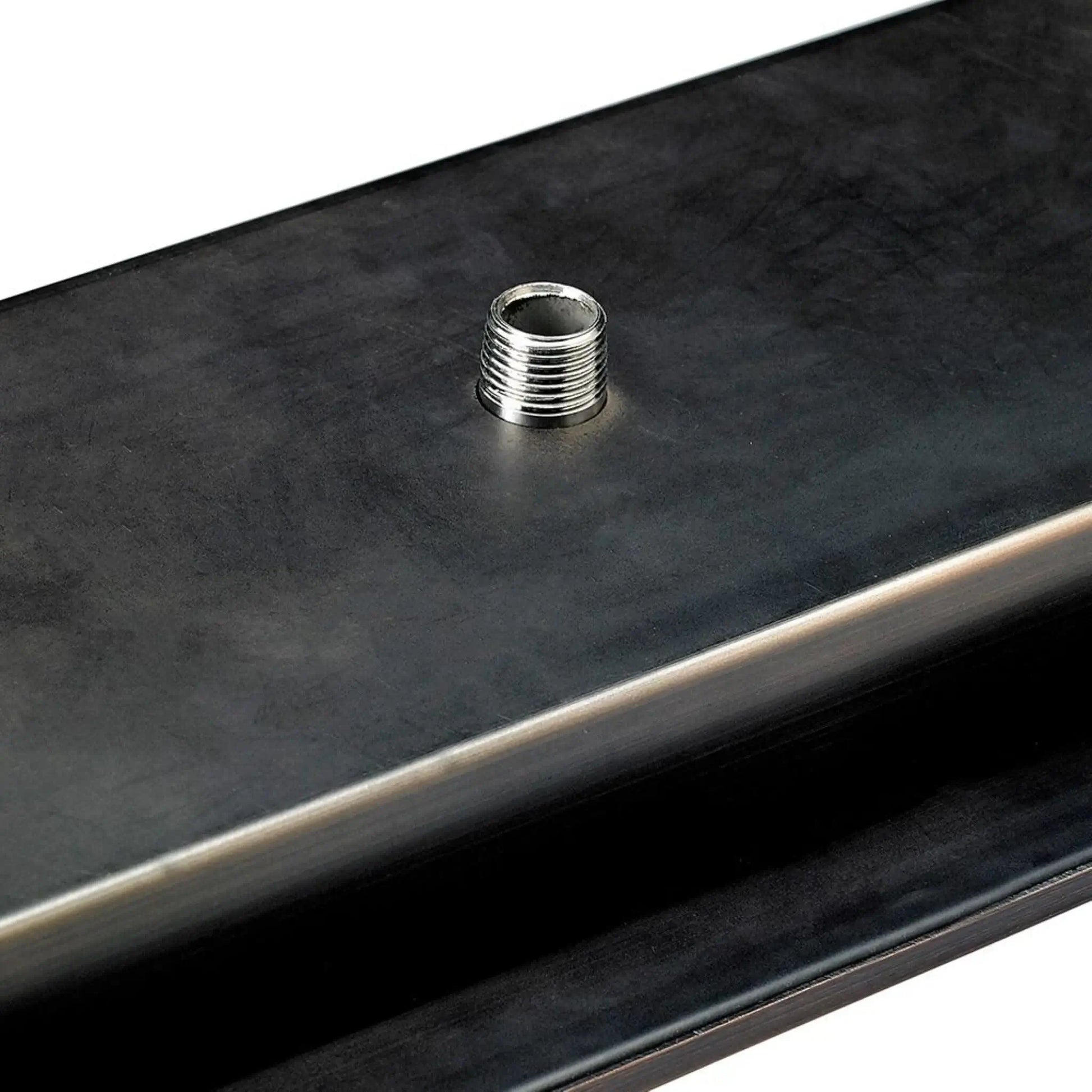 Close-up detail of the underside gas inlet nipple on an oil rubbed bronze linear drop-in burner pan from American Fire Products, highlighting the threaded gas connection used for secure outdoor fire pit installations.