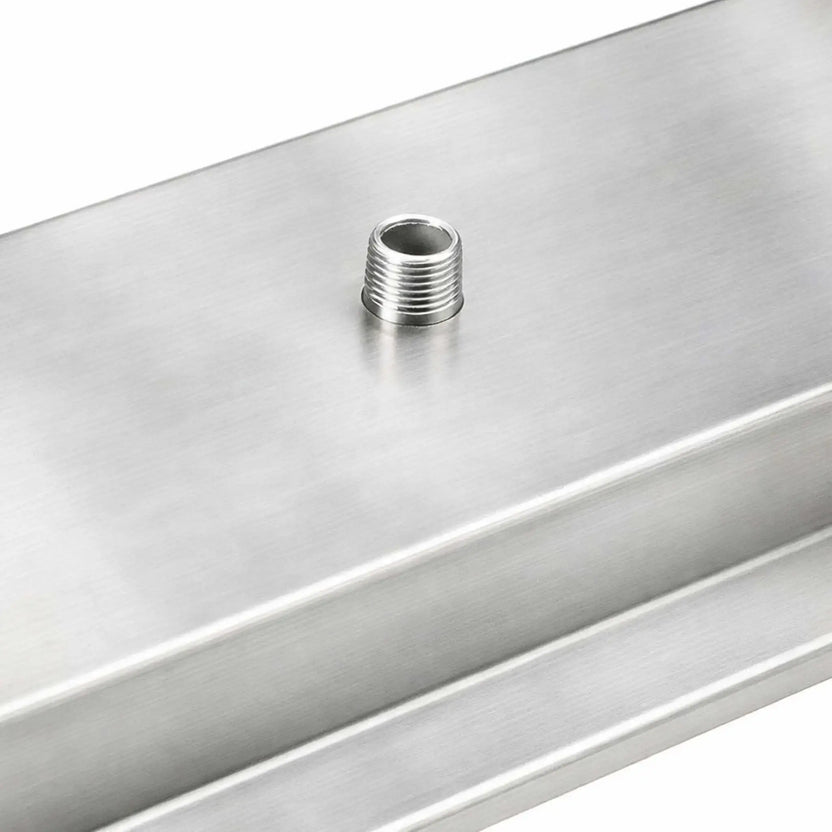 Close-up detail of the threaded gas inlet nipple on the underside of a stainless steel linear burner pan, showing the solid construction and secure gas connection point.