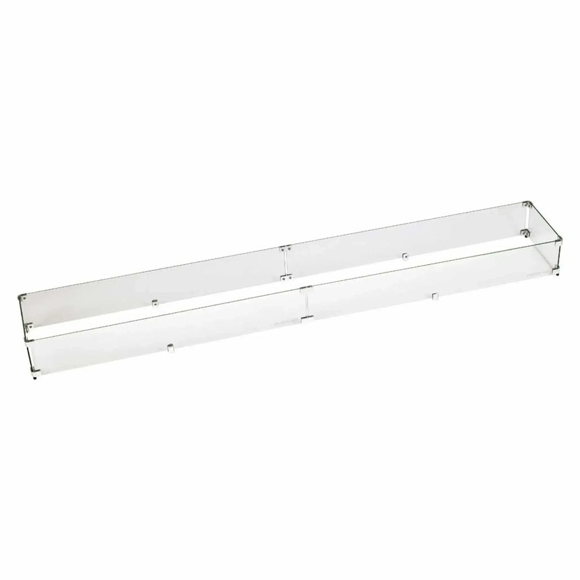 Oversized linear tempered glass wind guard made for extra-long fire pit burners, featuring transparent glass panels joined with metal brackets to maintain flame visibility while blocking wind.