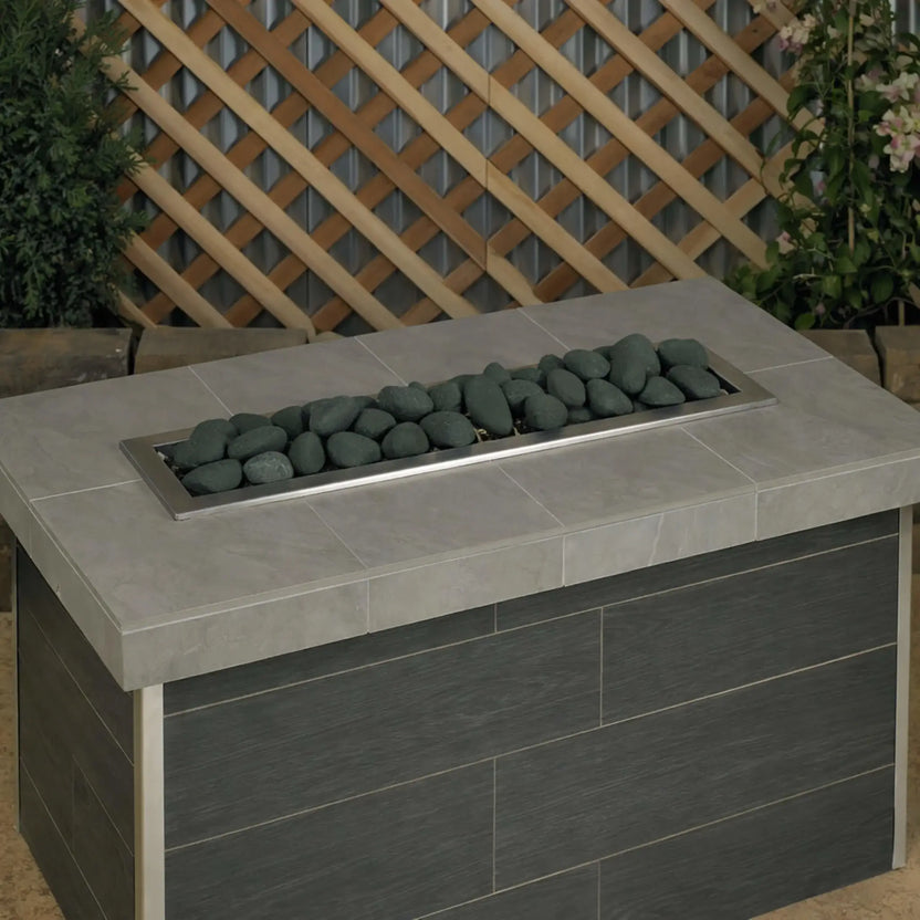 Rectangular outdoor gas fire table filled with Matte Black Lite Stones by American Fire Products, shown without flames to highlight the clean stone layout and contemporary black stone finish.
