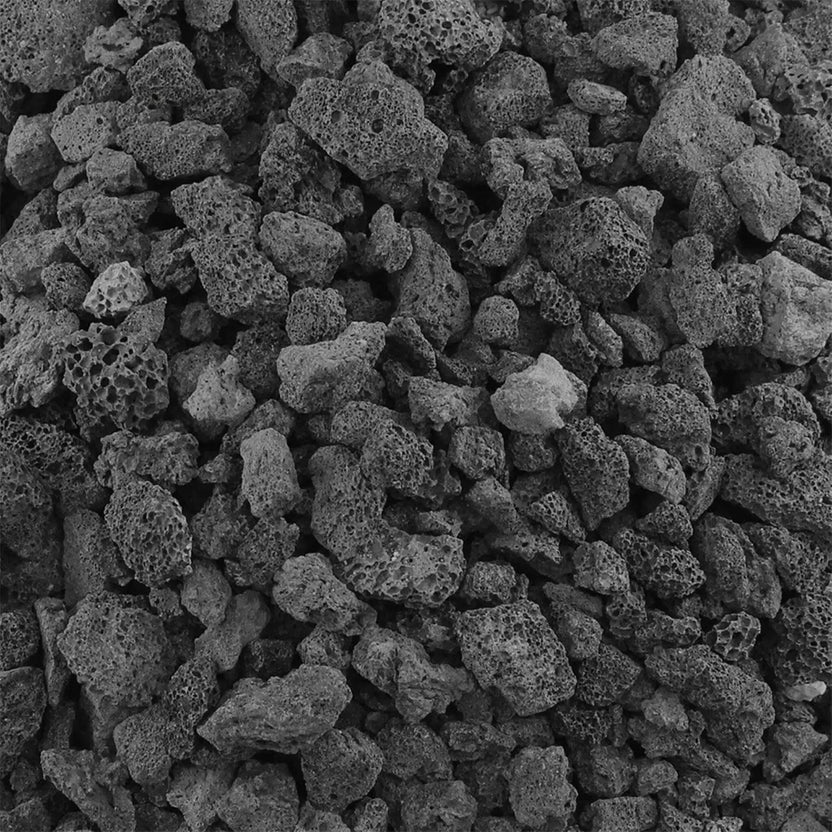Close-up of medium size black lava rock showing rough, porous volcanic texture designed for improved gas flow and even flame distribution in fire pits and fireplaces.