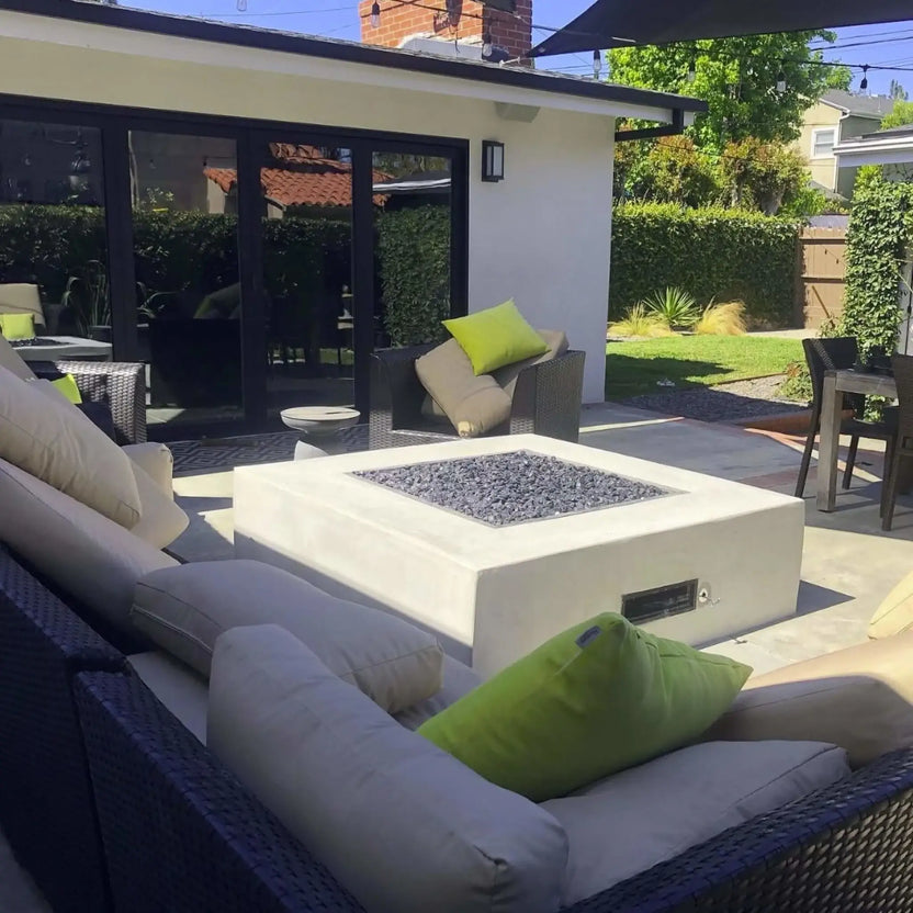 Modern backyard fire pit scene featuring a built in rectangular gas fire pit with glass media, showcasing a polished chrome universal gas key used for controlling the fire pit gas shut off valve.