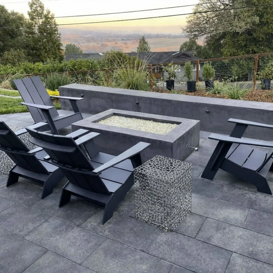 Outdoor patio fire pit installation using a polished chrome eight inch universal gas key, shown in a modern backyard setting with a rectangular fire pit surrounded by contemporary seating and stone hardscape.