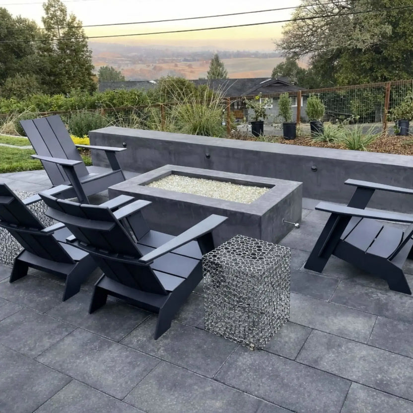 Outdoor patio fire pit installation using a polished chrome eight inch universal gas key, shown in a modern backyard setting with a rectangular fire pit surrounded by contemporary seating and stone hardscape.