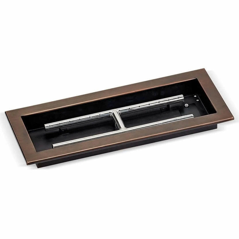 Oil-rubbed bronze rectangular drop-in burner pan measuring 18 by 6 inches, shown in a studio setting with exposed stainless steel burner bars and mounting flanges, designed for compact outdoor fire features.
