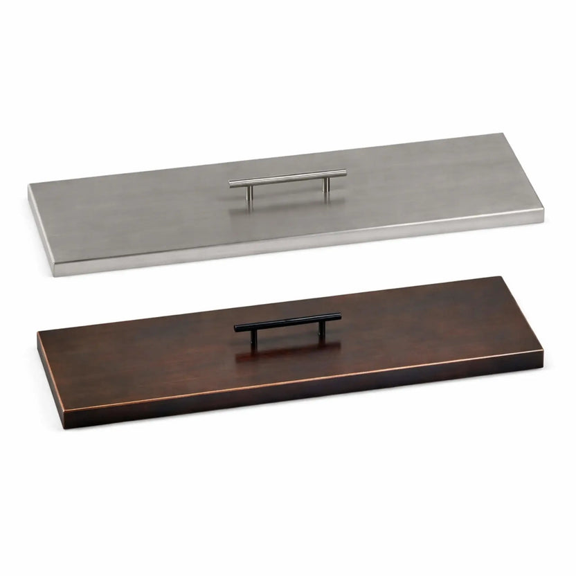 Side-by-side comparison of rectangular fire pit burner covers in brushed stainless steel and oil-rubbed bronze finishes, each featuring a flat design with a centered handle, displayed on a clean white background to highlight color and finish differences.