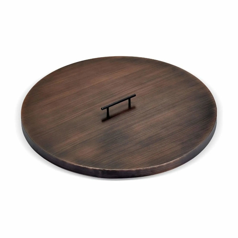 Round oil rubbed bronze fire pit burner cover with a smooth brushed finish and a low-profile raised handle centered on top, designed to protect gas burners while blending into outdoor fire pit tables.