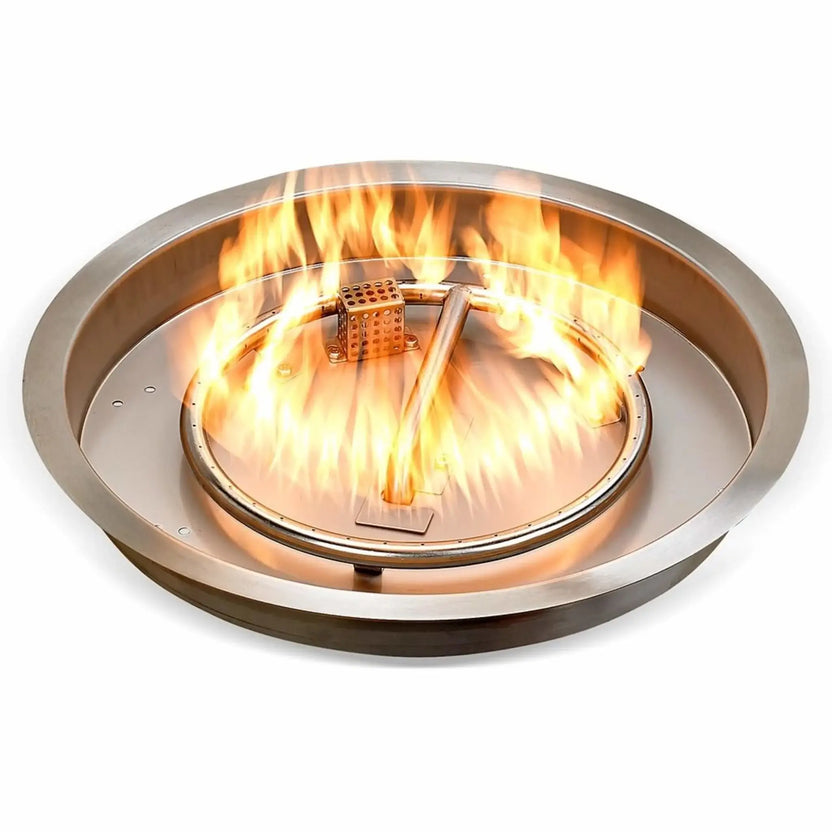 Round stainless steel drop-in fire pit pan operating with a full flame display, showing evenly distributed fire around the circular burner ring for consistent heat and visual appeal.