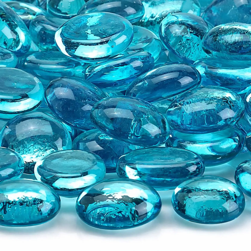 Close-up of aqua blue luster fire glass beads showing their translucent tempered glass construction, rounded edges, reflective surface, and subtle bubble detailing inside the glass.
