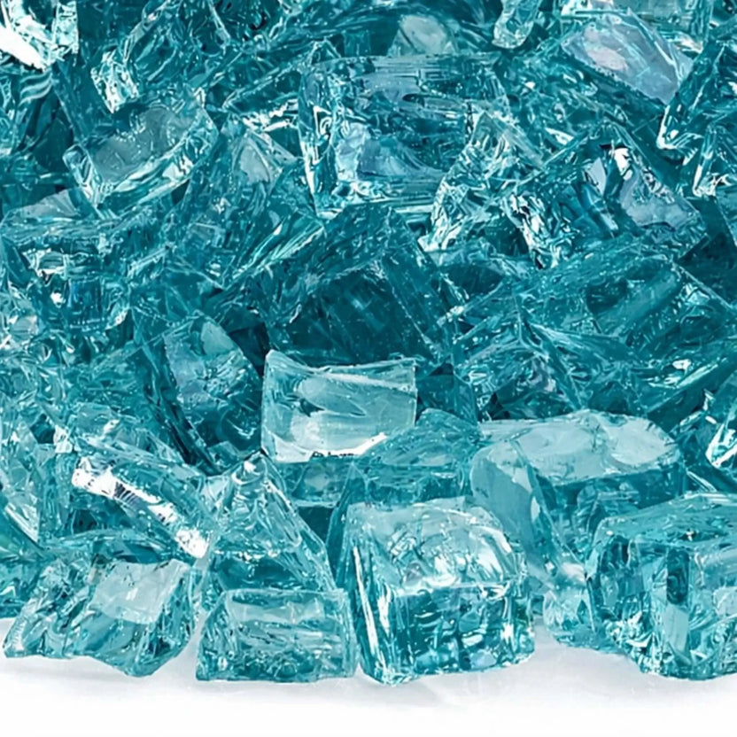 Close-up detail of Azuria 1/2 inch non-reflective tempered fire glass, highlighting the semi-translucent aqua color, smooth broken edges, and low-gloss finish designed to reduce glare in modern gas fire pit burners.