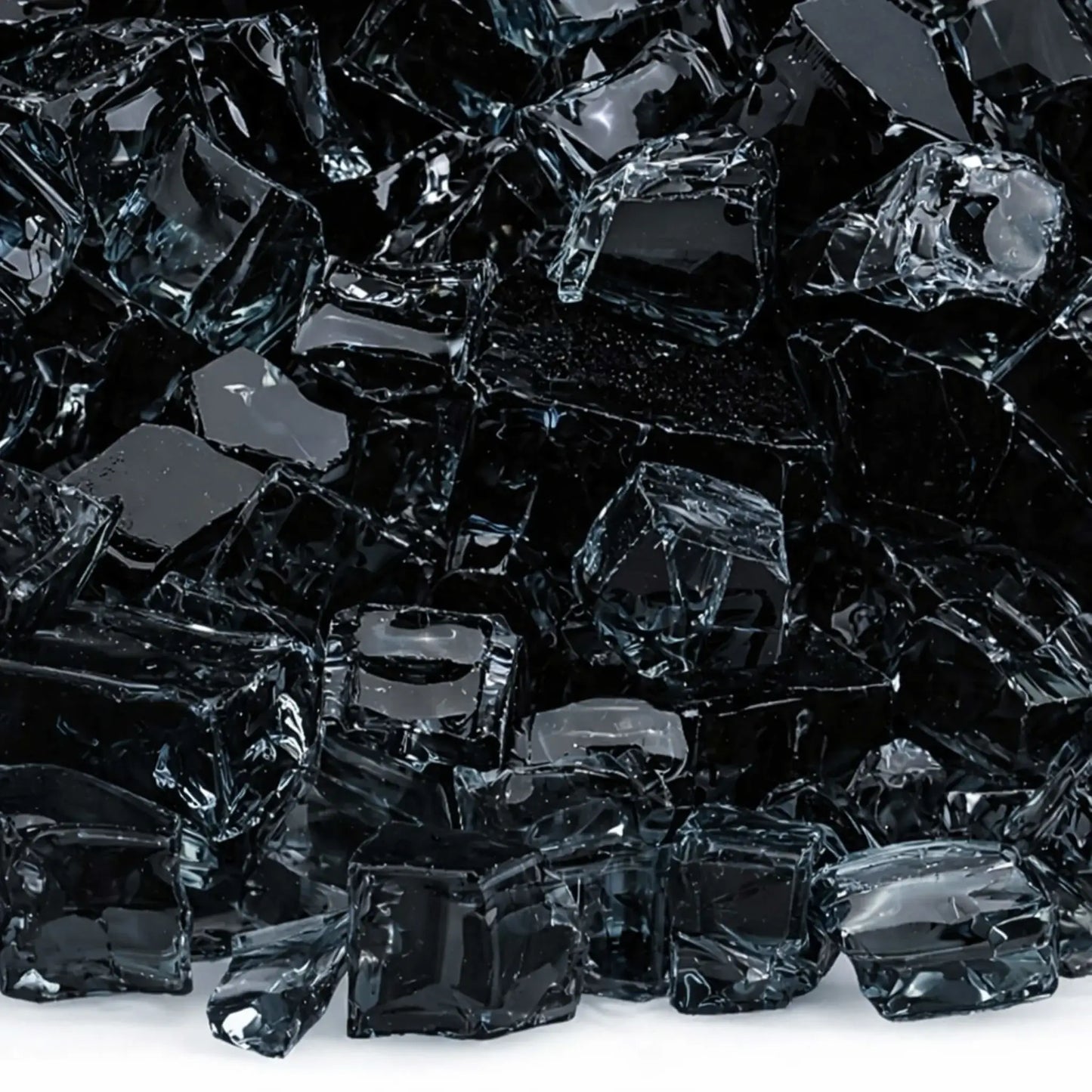 Macro close-up of 1/2 inch non-reflective black tempered fire glass pieces, showing glossy dark surfaces with softened edges and subtle light reflections, designed for contemporary gas fire pit media.