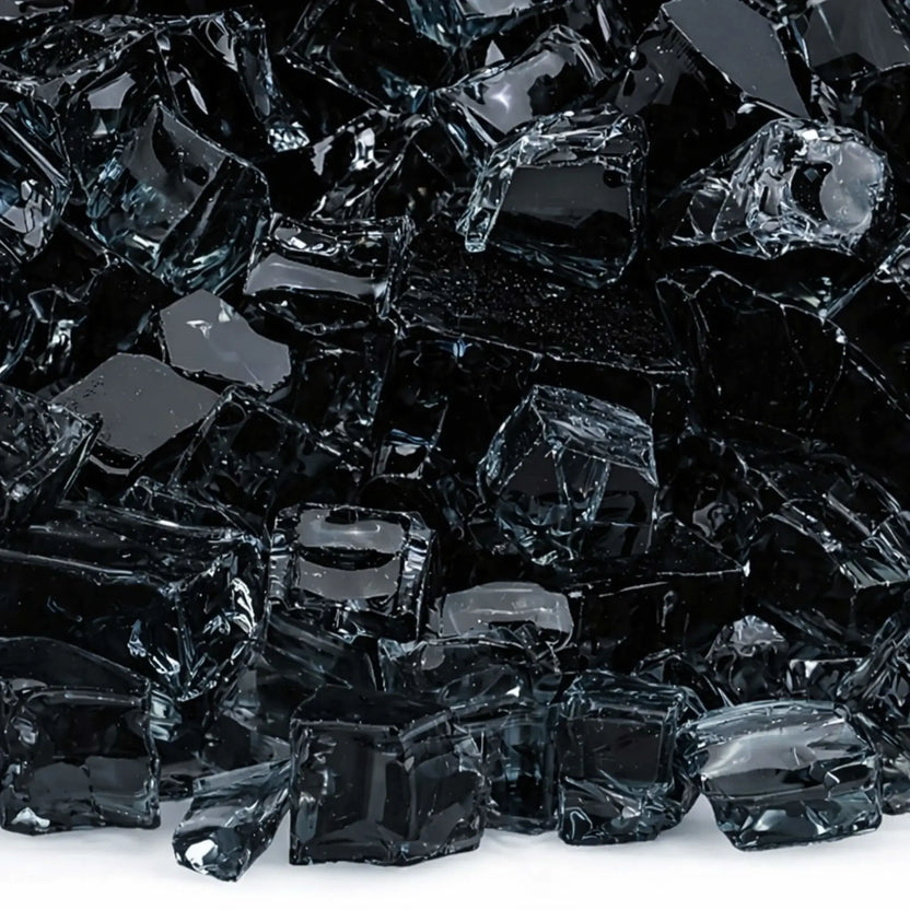 Macro close-up of 1/2 inch non-reflective black tempered fire glass pieces, showing glossy dark surfaces with softened edges and subtle light reflections, designed for contemporary gas fire pit media.