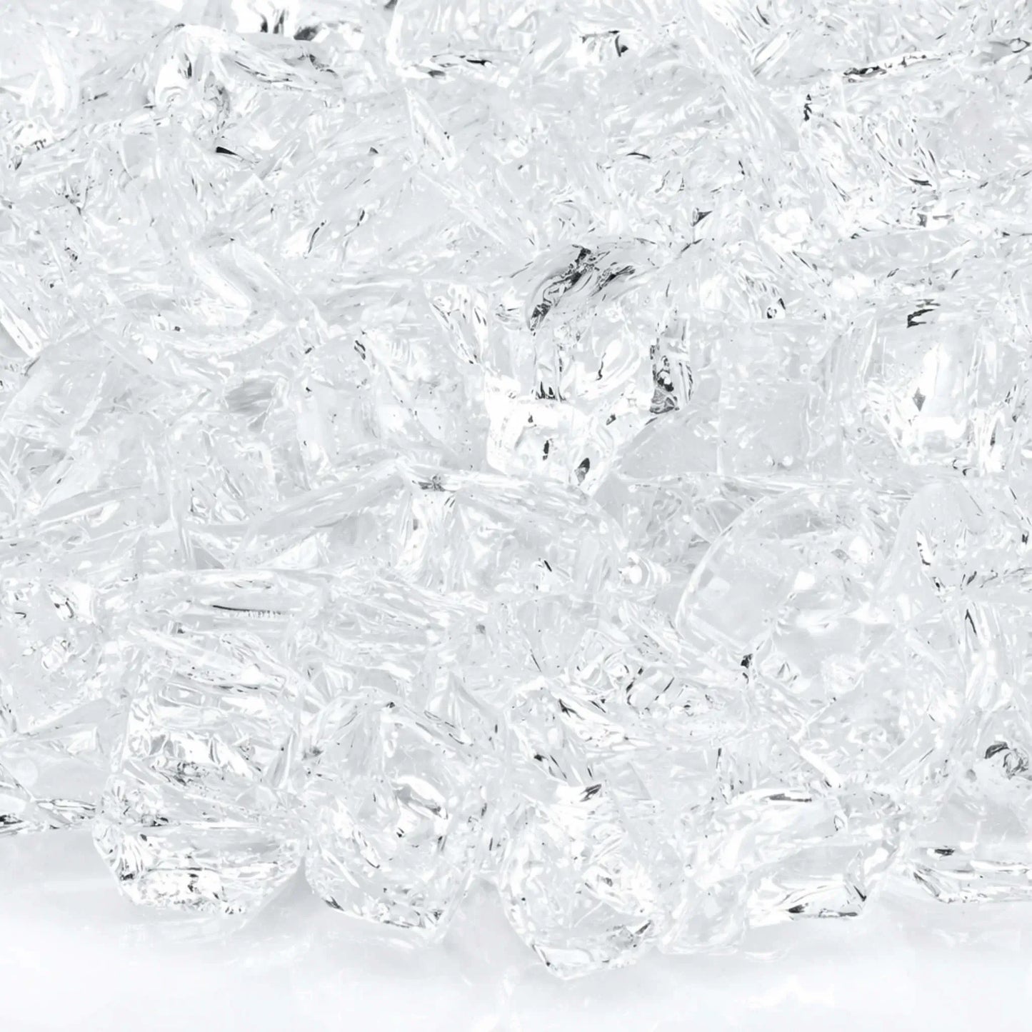 Macro close-up of 1/2 inch non-reflective Starfire Ultra Clear tempered fire glass pieces, showing brilliant clarity, subtle internal texture, and smooth tumbled surfaces that allow natural gas flames to shine through with bright, crisp illumination.