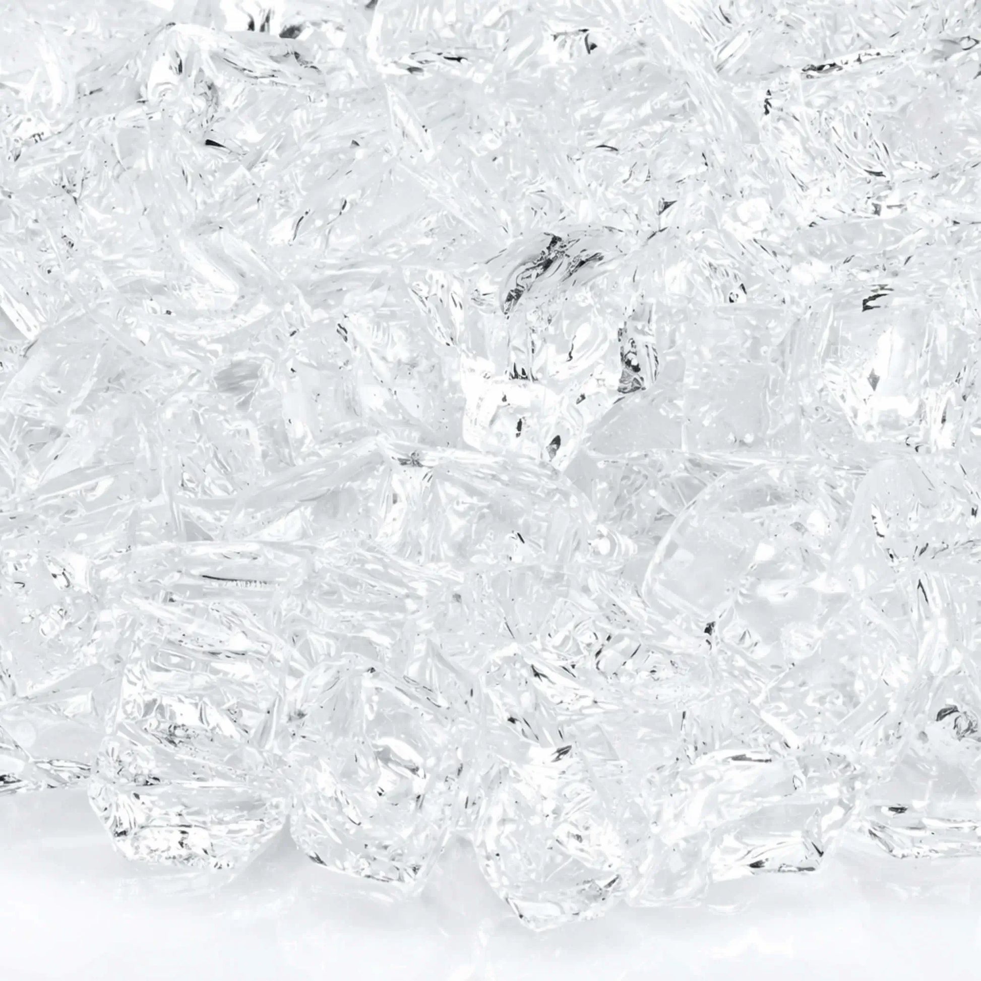 Macro close-up of 1/2 inch non-reflective Starfire Ultra Clear tempered fire glass pieces, showing brilliant clarity, subtle internal texture, and smooth tumbled surfaces that allow natural gas flames to shine through with bright, crisp illumination.