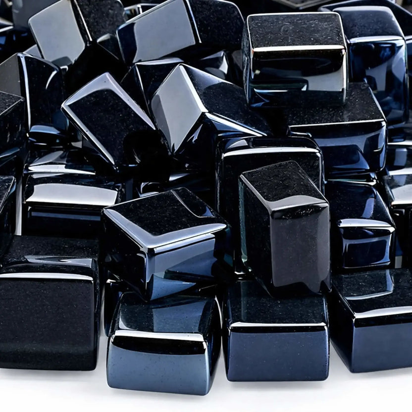 Tight close-up of glossy black tempered fire glass cubes from American Fire Products, featuring half-inch Luster 2.0 pieces with smooth, polished edges and a deep reflective finish. The cubes are stacked together, showing their rich, jet-black color and mirror-like surface that adds a sleek, modern look to gas fire pits and fireplaces.