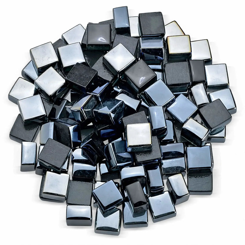 Top-down studio view of black Luster 2.0 half-inch tempered fire glass cubes arranged in a loose circular pile on a white background. The polished, mirror-like surfaces and beveled edges highlight the depth and reflective quality ideal for gas fireplaces and fire pits.