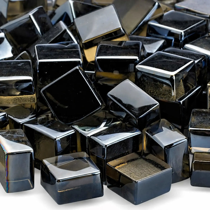 Detailed close-up of bronze tempered fire glass cubes in the Luster 2.0 finish, showing their smooth edges and reflective, smoky amber tones. The polished surfaces catch the light, emphasizing the depth and warmth these cubes bring to modern fire features.