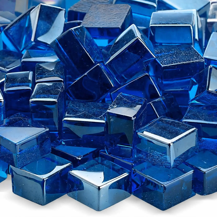 Close-up view of Pacific blue Luster 2.0 tempered fire glass cubes highlighting their smooth edges, reflective surfaces, and deep blue translucence. The light catches the glass facets, emphasizing the rich color saturation and polished finish.