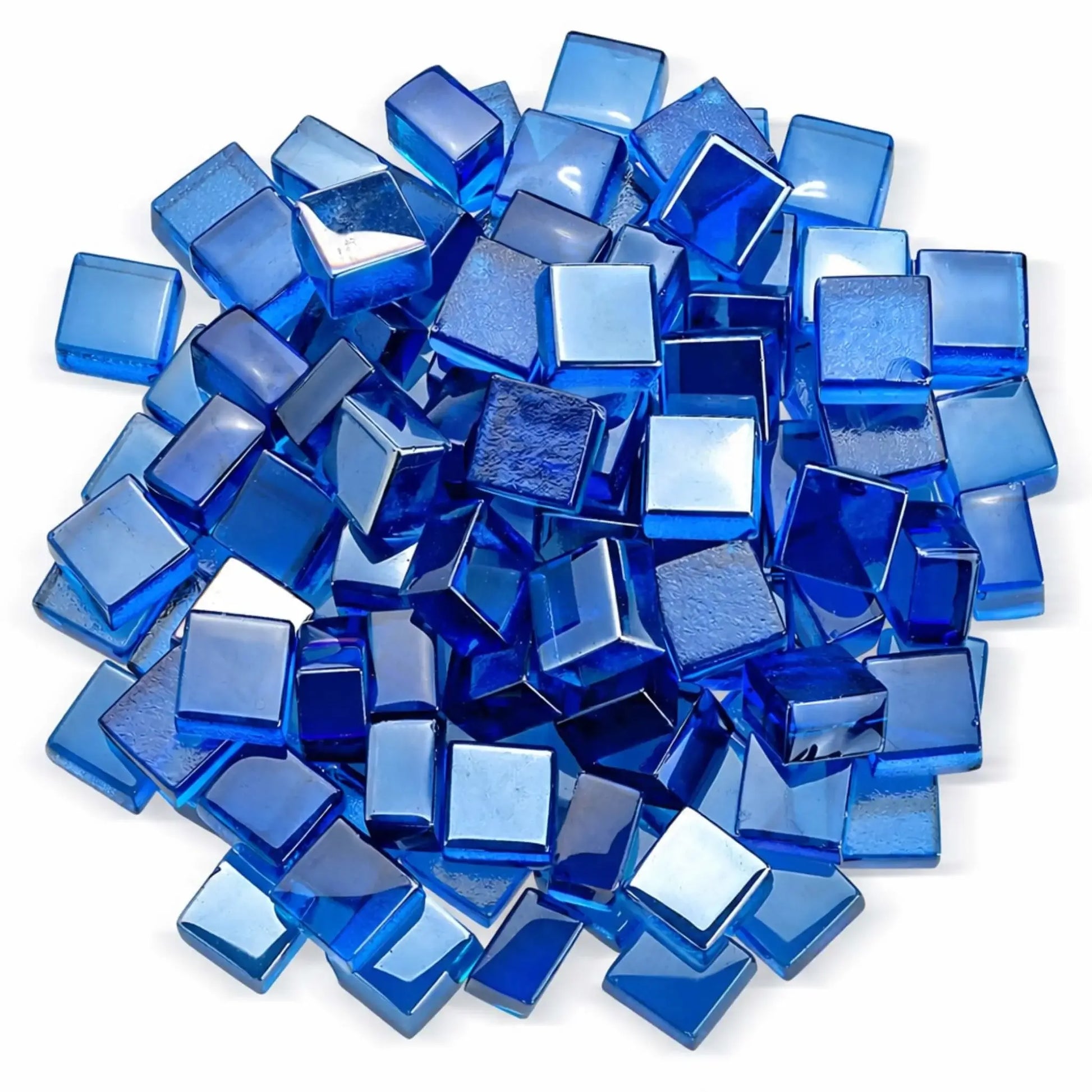 Overhead studio shot of Pacific blue Luster 2.0 half-inch tempered fire glass cubes arranged in a circular pile on a white background. The polished, translucent blue cubes reflect light from multiple angles, showcasing their smooth edges and jewel-like finish.