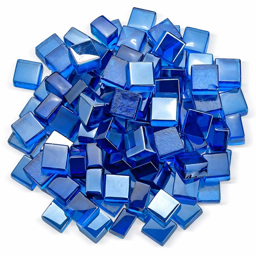 Overhead studio shot of Pacific blue Luster 2.0 half-inch tempered fire glass cubes arranged in a circular pile on a white background. The polished, translucent blue cubes reflect light from multiple angles, showcasing their smooth edges and jewel-like finish.