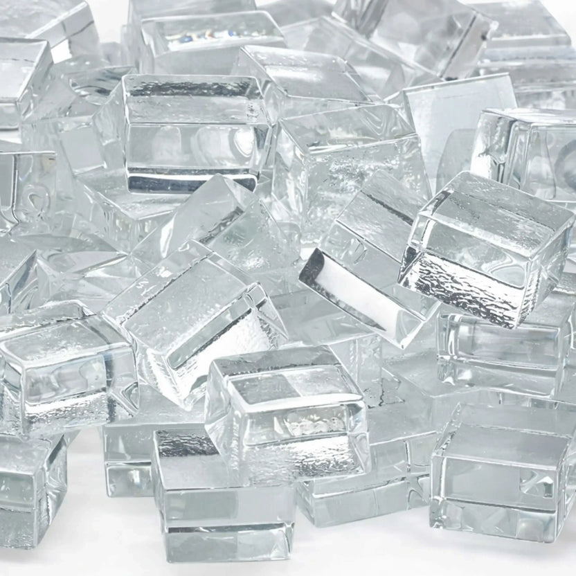 Detailed close-up of Starfire clear white tempered fire glass cubes highlighting their smooth, polished edges and crystal-clear transparency. Subtle internal reflections and textured undersides add dimension and brilliance to the glass pieces.