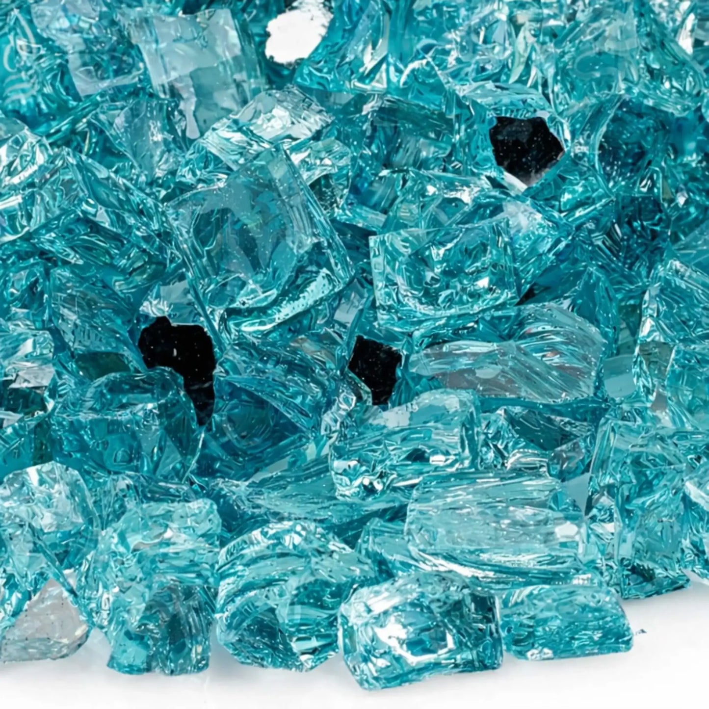 Close-up macro view of 1/2 inch reflective Azuria tempered fire glass from American Fire Products, highlighting the translucent aqua blue color, sharp faceted edges, smooth polished surfaces, and reflective backing that enhances light and flame brilliance.
