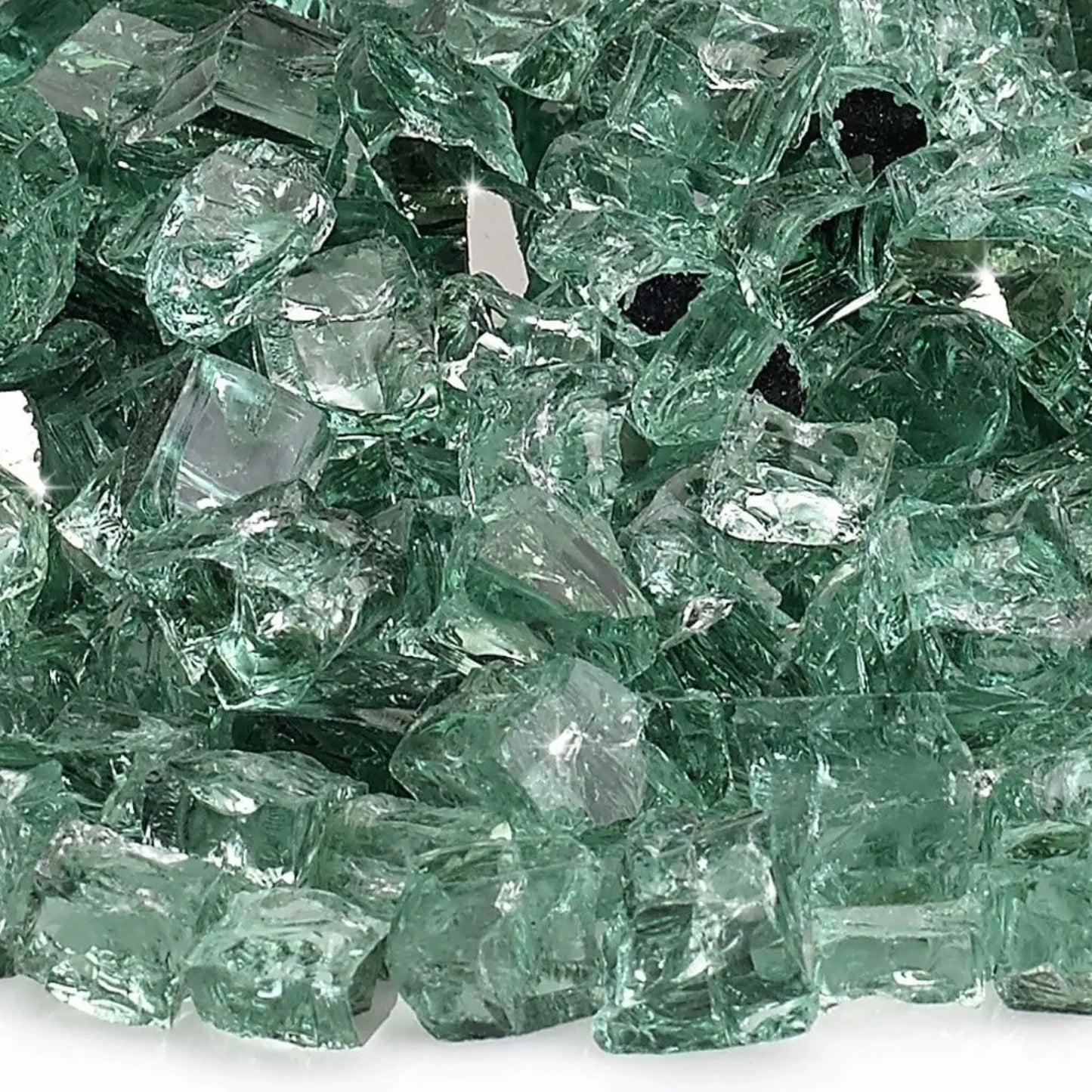Close-up macro image of 1/2 inch premium reflective evergreen green tempered fire glass by American Fire Products, showing the subtle green tint, smooth polished surfaces, sharp angular fragments, and mirrored coating that intensifies light and flame sparkle.