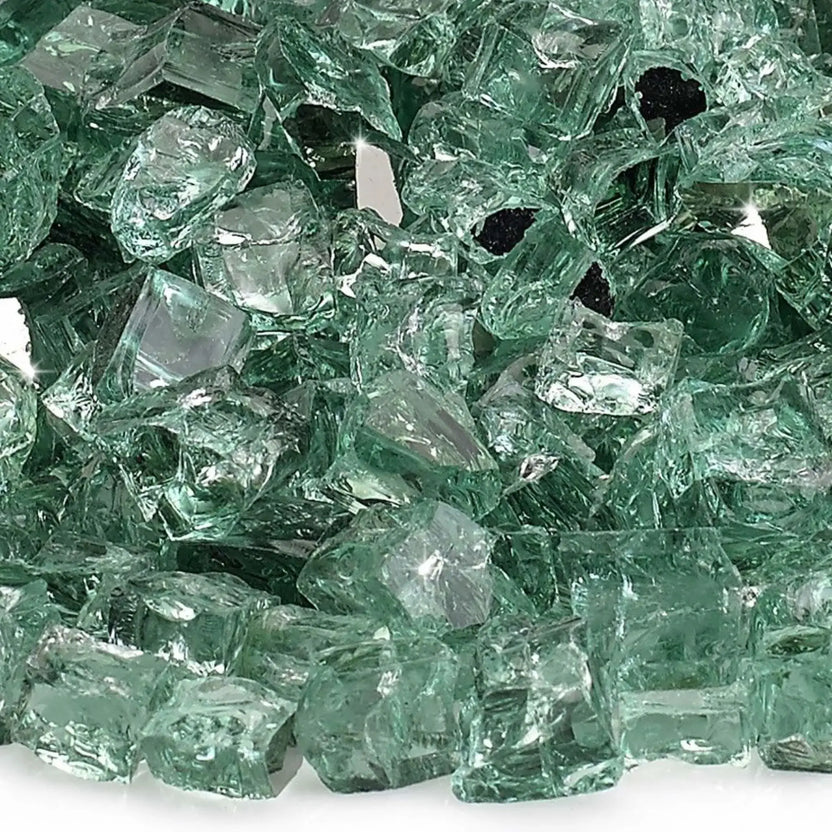 Close-up macro image of 1/2 inch premium reflective evergreen green tempered fire glass by American Fire Products, showing the subtle green tint, smooth polished surfaces, sharp angular fragments, and mirrored coating that intensifies light and flame sparkle.