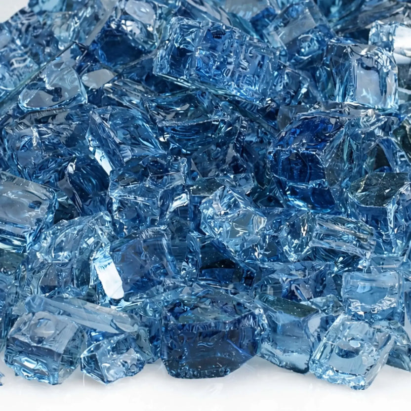 Detailed macro image of 1/2 inch premium reflective Pacific blue fire glass, revealing rich ocean-blue tones, smooth polished edges, angular shards, and reflective undersides that intensify light and flame brilliance in gas fireplaces and fire pits.
