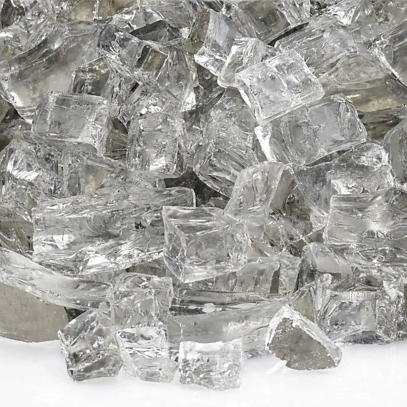Close-up view of 1/2 inch premium reflective Starfire ultra clear titanium fire glass, showing transparent tempered fragments with smooth polished surfaces and mirrored undersides that amplify brightness and create a clean, modern fire feature look.