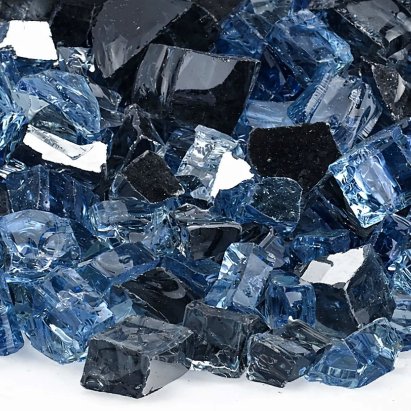 Close-up of Maui Breeze 1/2 inch reflective fire glass showing detailed textures of dark charcoal and layered blue glass chunks, each with smooth tumbled edges and reflective surfaces that catch the light.