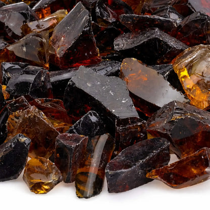 Close-up detail of Auburn tempered fire glass showing jagged, polished edges and layered tones of honey, caramel, and dark espresso brown with light reflecting through the translucent shards.