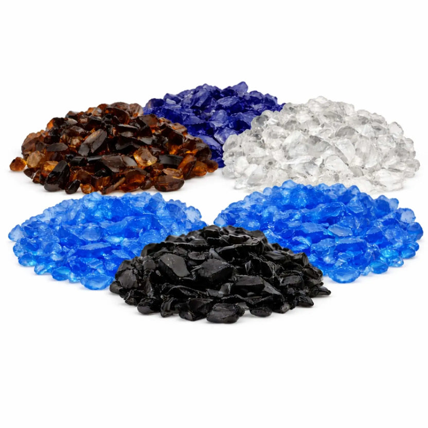 Assorted American Fire Products tempered fire glass colors displayed in separate piles, including Auburn, dark blue, light turquoise, ice clear, white onyx, and glossy black for decorative gas fire features.