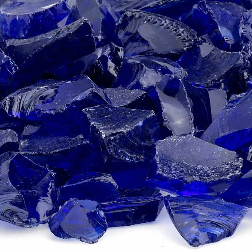 Close-up of dark blue fire glass showing smooth fractured edges and rich sapphire tones with subtle variations in transparency and shine.