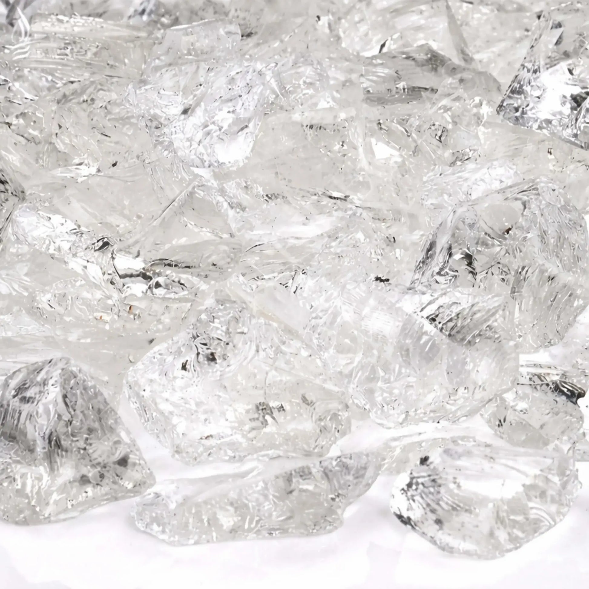 Close-up detail of Ice White fire glass highlighting smooth fractured edges, crystal-clear transparency, and subtle reflective sparkle under bright lighting.