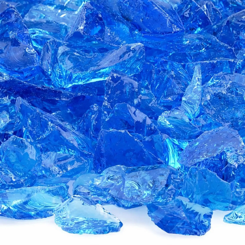 Close-up of turquoise blue fire glass pieces revealing layered blue-green hues, smooth tempered edges, and shimmering reflections under bright lighting.
