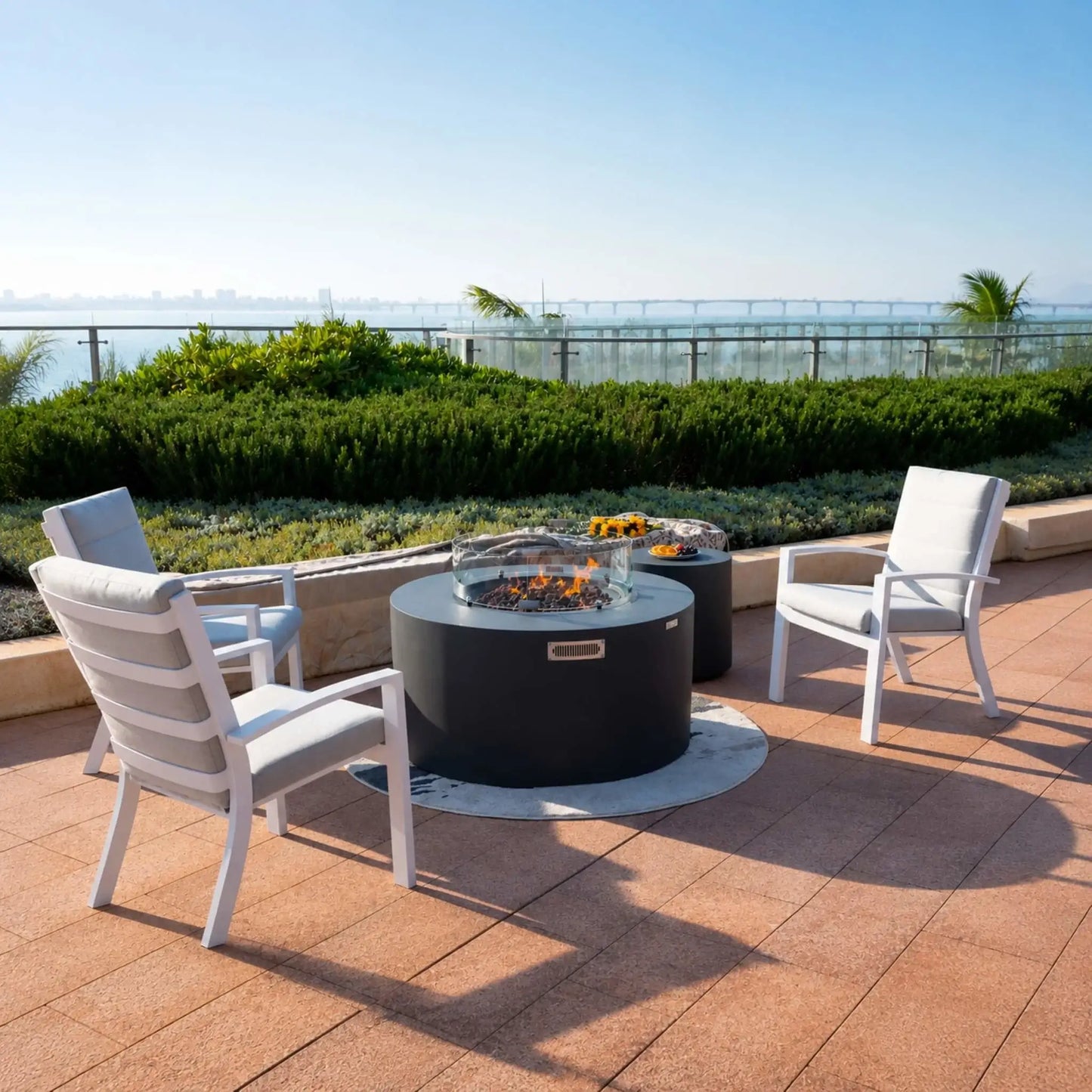 Close-up of the Elementi Art of Living Pacaya Dark Grey round fire pit table showing the hidden propane drawer system extended for easy tank access. The concealed propane cylinder slides out from within the GFRC concrete fire table, demonstrating the integrated hidden storage design that keeps the outdoor fire feature clean, organized, and visually uncluttered.