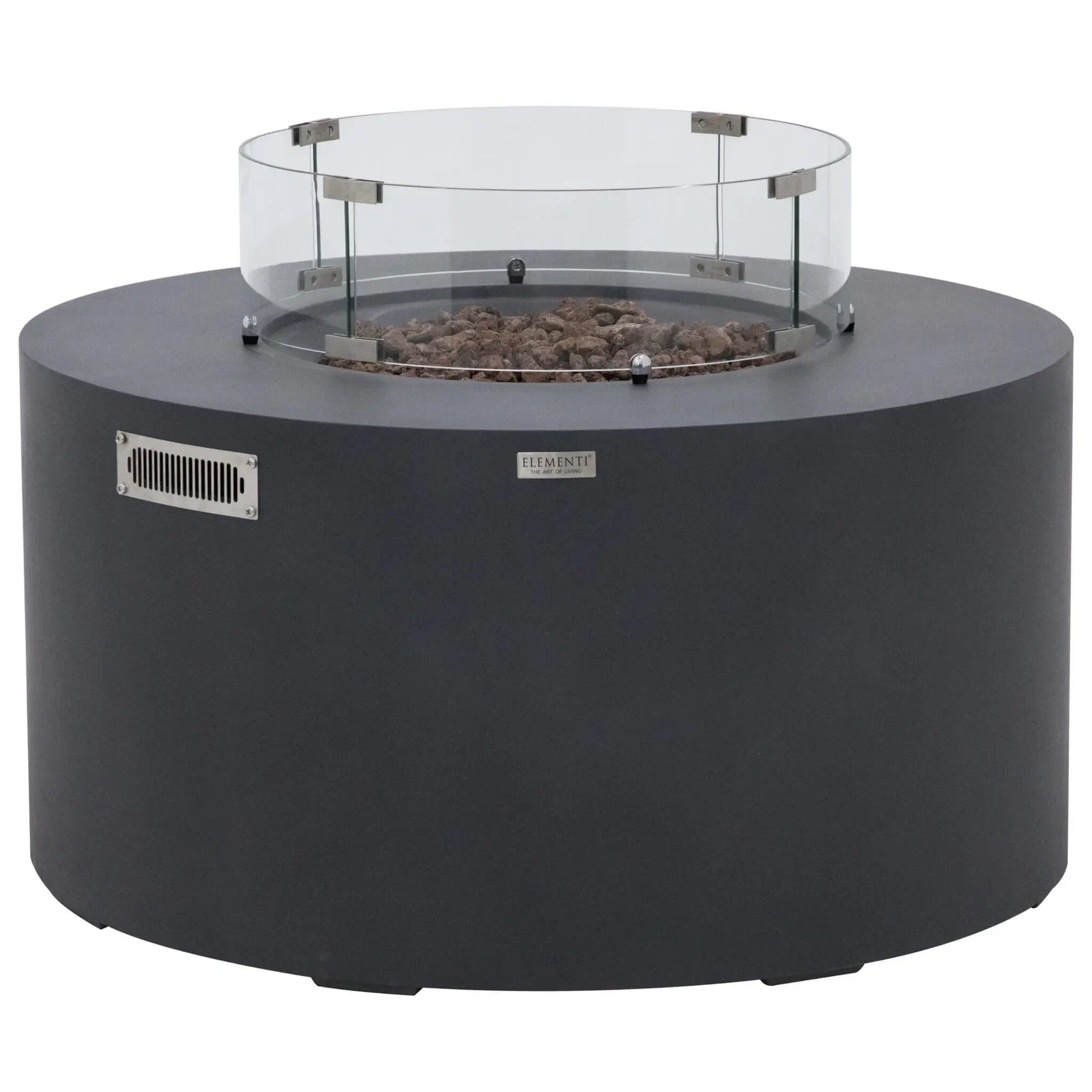 Front view of the Elementi Art of Living Pacaya Dark Grey round GFRC concrete fire pit table equipped with a circular tempered glass wind guard. The recessed lava rock burner area is enclosed by the transparent glass barrier, while the cylindrical fire table body, ventilation panel, and hidden propane storage design are displayed against a clean white background.