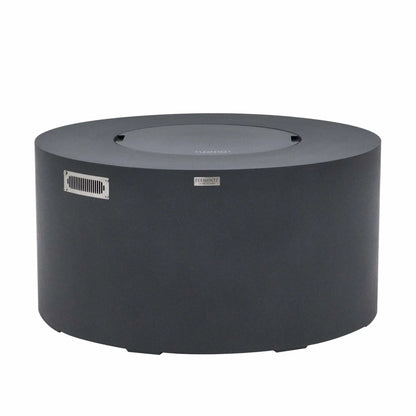 Front product view of the Elementi Art of Living Pacaya Dark Grey round GFRC concrete fire pit table with the burner area covered by its matching lid. This hidden propane fire pit table features a smooth cylindrical design, integrated ventilation panel, concealed propane storage system, and durable dark grey finish, displayed on a clean white background for product catalog and ecommerce presentation.